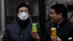 Doanh nhân triệu phú Trần Quang Tiêu (phải) đưa một lon không khí sạch cho một người đeo mặt nạ tại trung tâm thủ đô Bắc Kinh.