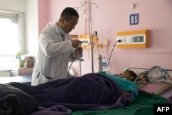 Perdana Menteri Bhutan Lotay Tshering merawat seorang pasien di Rumah Sakit Rujukan Nasional di ibu kota Bhutan, Timphu, 30 Maret 2019.