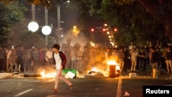 Demonstrators set fire to trash cans as they protest against a chemical plant project, on a street in Maoming, Guangdong province, China, early April 1, 2014.