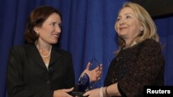 La secretaria de Estado Hillary Clinton entrega el premio Common Ground en honor al malogrado embajador Chris Stevens a su hermana, Anne Stevens, en el Instituto Carnegie para la Ciencia, en Washington, el 8 de noviembre de 2012.