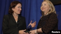Menlu AS Hillary Clinton (kanan) menyerahkan Penghargaan "Common Ground" untuk menghormati almarhum Christopher Stevens yang terbunuh di Libya kepada saudara perempuannya, Anne Stevens di Washington DC (8/11).
