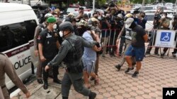 Police officers accused of complicity in the killing of a suspected drug dealer are brought to Nakhon Sawan Provincial Court, in Nakhon Sawan province, Thailand, Aug. 26, 2021. 