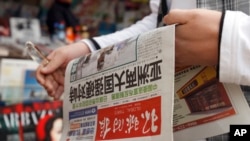 一个中国人拿着《环球时报》，2010年。(资料图)