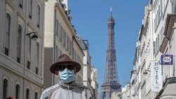 Un hombre usa una máscara para protegerse del coronavirus mientras camina por una calle cercana a la Torre Eiffel en París, el domingo 26 de abril de 2020.