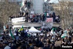FILE - Demonstrators gather around the Monument to the Republic during a protest against President Abdelaziz Bouteflika seeking a fifth term in a presidential election set for April 18, in Paris, France, Feb. 14, 2019.