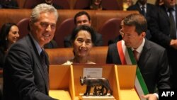 Pemenang Nobel Perdamaian dan pemimpin oposisi Burma Aung San Suu Kyi (kanan) berfoto bersama Walikota Ignazio Marino (kanan) dan mantan menteri serta walikota Roma Francesco Rutelli dalam upacara di Campidoglio di Roma (27/10). (AFP/Tiziana Fabi)