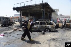 Firefighters work at the site of a deadly suicide attack in Jalalabad, the capital of Nangarhar province, Afghanistan, July 10, 2018.