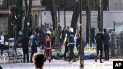 FILE - This image from video shows medics and security members with injured people lying on the ground after an explosion at Istanbul's historic Sultanahmet district, which is popular with tourists, Jan. 12, 2016.