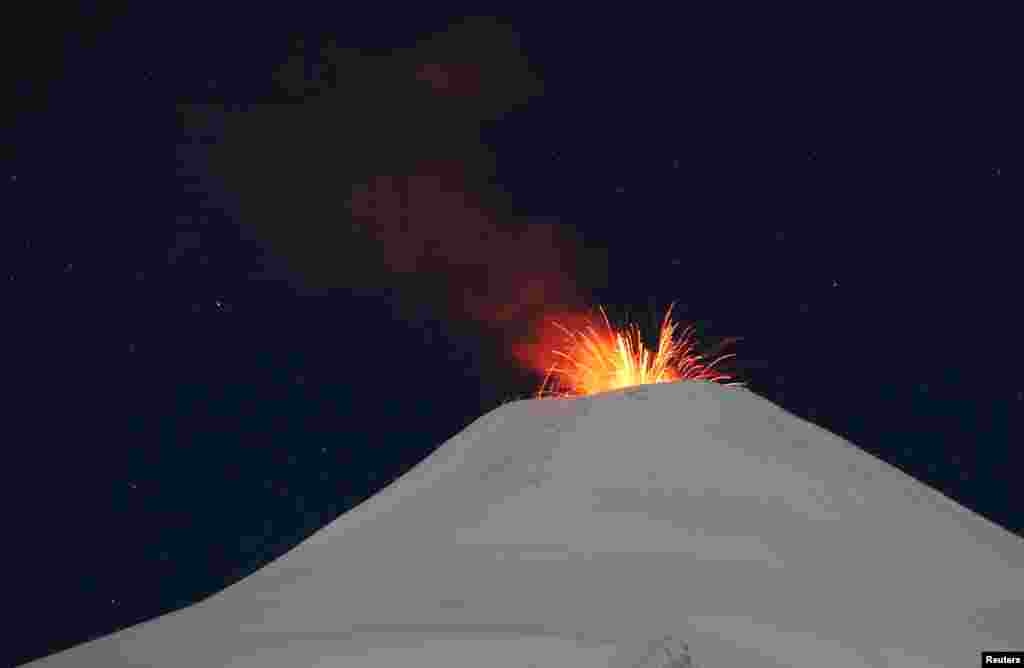 The Villarrica volcano shoots up lava at night, as seen from the town of Pucon, Chile.