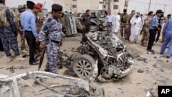 Iraqi security forces inspect the site of a car bomb attack in Basra, Iraq, March 17, 2013. 