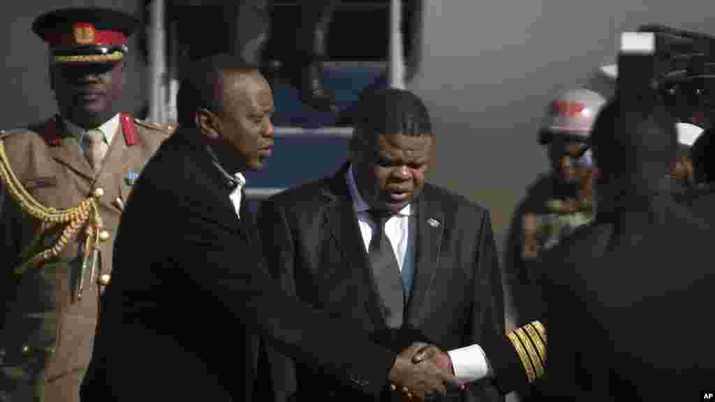 Le président kenyan Uhuru Kenyatta (à gauche) accompagné par le ministre sud-africain de la Sécurité d&#39;Etat David Mahlobo (à droite) arrive à la base aérienne de Waterkloof, à Pretoria, Afrique du Sud, samedi Juin 13 2015, la veille du Sommet de l&#39;Unité africaine (UA).