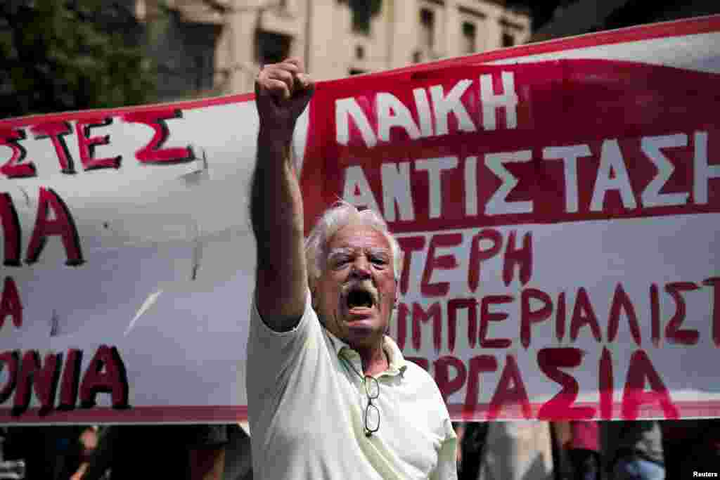 Seorang demonstran meneriakkan slogan ketika ikut reli yang diselenggarakan oleh serikat sektor publik terbesar negara tersebut ADEDY yang menandakan pemogokan selama 24 jam di Athena, Yunani.