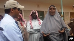 USAID Administrator Rajiv Shah, left, speaks with the chairwoman of community effort to distribute food and clothes to new arrivals at Dadaab refugee camp, Kenya July 20, 2011