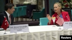 Foreign Affairs Minister Ahmet Davutoglu of Turkey listens to U.S. Secretary of State Hillary Clinton as they attend a "Friends of Syria" meeting in Istanbul June 6, 2012.