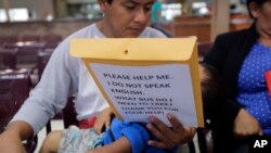 Immigrants from Guatemala seeking asylum look over travel packets as they wait at the bus station after they were processed and released by U.S. Customs and Border Protection, June 21, 2018, in McAllen, Texas. 