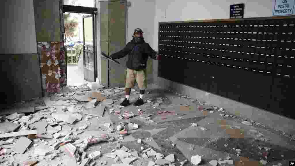 Jorge Sanchez looks over damage to the main post office following an earthquake in Napa, California, Aug. 24, 2014.