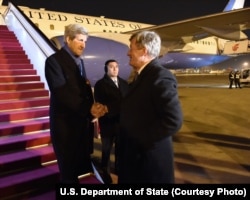 U.S. Secretary of State John Kerry shakes hands with U.S. Ambassador to China Max Baucus, a former U.S. Senate colleague, after arriving at Beijing International Airport in Beijing, China, Jan. 26, 2016,