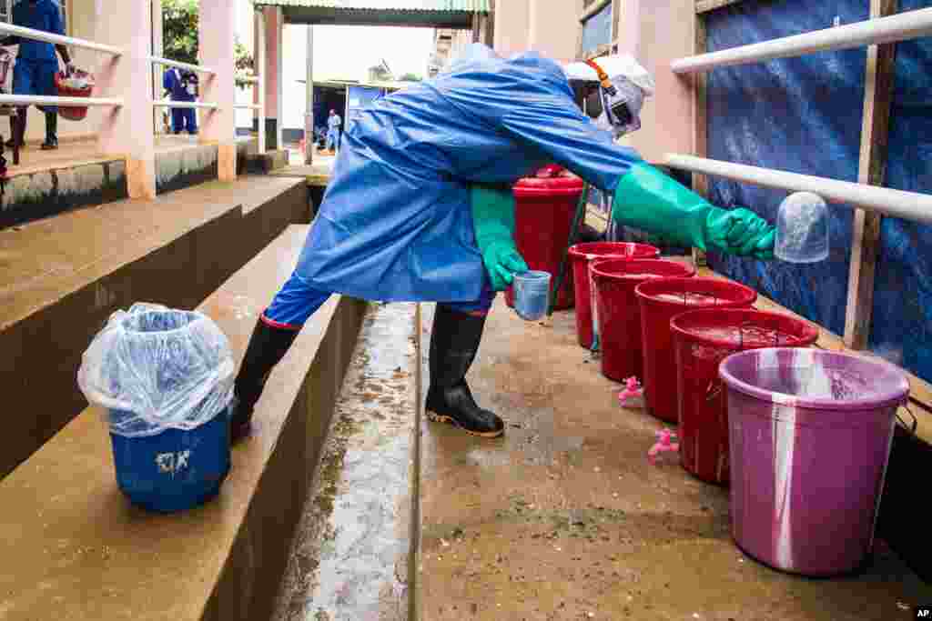 A healthcare worker mixes chlorine with water at an Ebola treatment center in Hastings, Freetown, Sierra Leone, Oct. 15, 2014. 