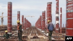 FILE - A picture taken on June 14, 2015 shows Chinese laborers working in Algiers at the construction site of the third largest mosque in the area and the largest in Africa.