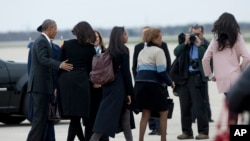 The first family, from left, President Barack Obama, Michelle Obama, their daughters Sasha and Malia, and mother-in-law Marian Robinson, fourth from left, walk to board the Air Force One for a trip Havana, Cuba, March 20, 2016.