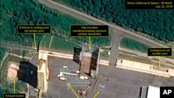 FILE - This July 22, 2018, satellite image released and annotated by 38 North on July 23, shows what the US research group says is the partial dismantling of the rail-mounted transfer structure (C) at the Sohae launch site in North Korea. 