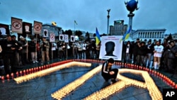 A person lights a candle to help form the name Giya, nickname of Georgy Gongadze, during a memorial rally on Independence square in Kiev (file photo - 16 Sep 2008)