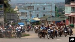 Ratusan umat Budha bersepeda motor lengkap dengan senjata pentungan melakukan patroli di jalanan kota Lashio, Burma timur, Rabu (29/5).