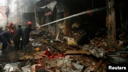 Vatrogasci pokušavaju da ugase požar na mestu napada u Pešavaru, u Pakistanu