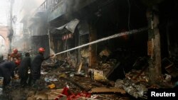 Firefighters work to extinguish a fire from a building at the site of a lethal bomb attack in Peshawar September 29, 2013.