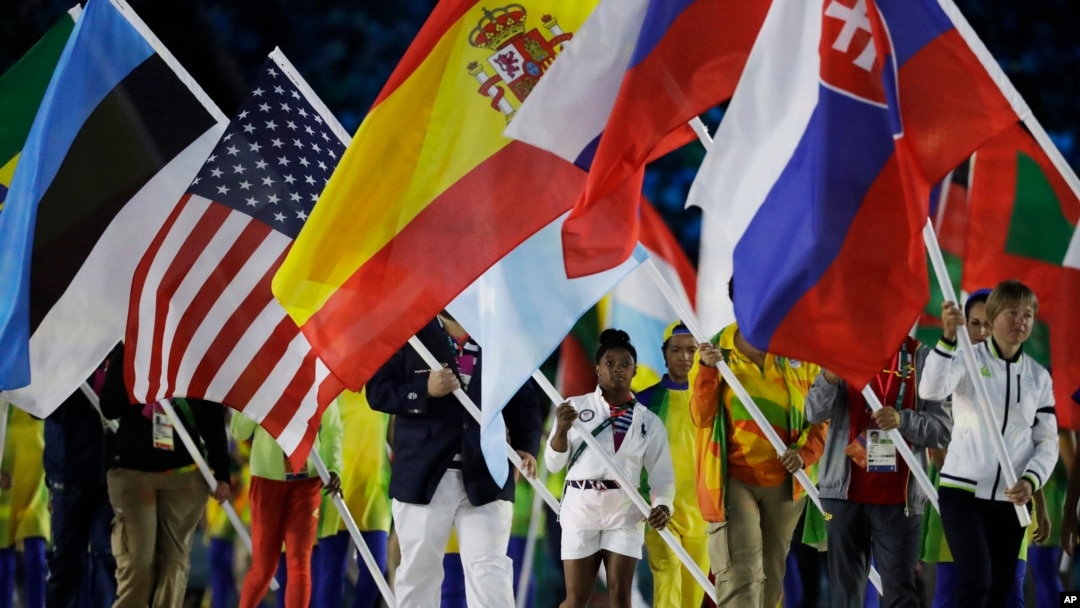 Vận động viên thể dục dụng cụ của đội Mỹ Simone Biles cầm quốc kỳ tại lễ bế mạc.