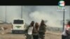 Rekaman video yang diperoleh AFPTV dari TVGE pada 7 Maret 2021 ini memperlihatkan seorang pria terluka sedang dibantu oleh tentara di Bata, Guinea Khatulistiwa.(AFP Photo/TVGE) 
