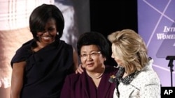 U.S. first lady Michelle Obama (L) and Secretary of State Hillary Clinton (R) honor Kyrgyzstan President Roza Otunbayeva during the International Women of Courage Awards Ceremony at the State Department, March 8, 2011