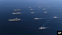 In this Nov. 12, 2017 photo provided by South Korea Defense Ministry, three U.S. aircraft carriers USS Nimitz, left top, USS Ronald Reagan, left center, and USS Theodore Roosevelt, left bottom, participate with other U.S. and South Korean navy ships during joint naval exercises between the United States and South Korea in waters off South Korea's eastern coast. 