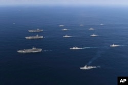 In this Nov. 12, 2017 photo provided by South Korea Defense Ministry, three U.S. aircraft carriers USS Nimitz, left top, USS Ronald Reagan, left center, and USS Theodore Roosevelt, left bottom, participate with other U.S. and South Korean navy ships.