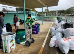 Genshu Price (kanan) dan relawan lainnya di S.W. King Intermediate School di Kāne'ohe, Hawaii, menyortir kaleng dan botol untuk "Bottles4College", 18 Maret 2021. (Foto: Maria Price/Bottles4College via AP)