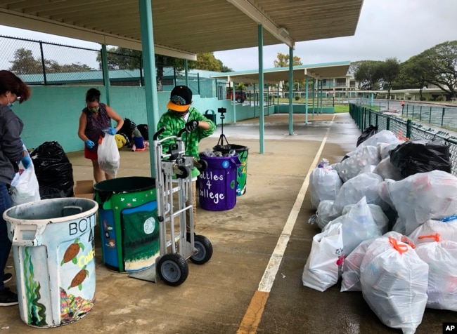 Genshu Price, kanan, dan relawan lainnya di S.W. King Intermediate School di Kāne'ohe, Hawaii, menyortir kaleng dan botol untuk Bottles4College. (Foto: AP)