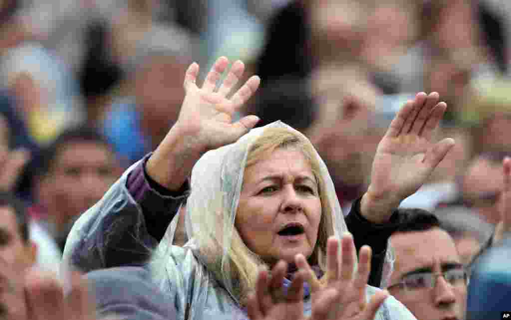 People pray during a Mass celebrated by Pope Francis outside the Aparecida Basilica in Aparecida, Brazil, Wednesday, July 24, 2013. 