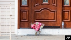 Ramos de flores fueron dejados en la puerta de la casa de un rabino en Monsey, Nueva York, el domingo 29 de diciembre de 2019, tras un ataque con cuchillo en la residencia el sábado por la noche, que dejó cinco heridos. AP/Julius Constantine Motal.