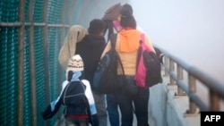 A Honduran family walks back to Piedras Negras, Coahuila state, Mexico at the international bridge, after being rejected by U.S. authorities in their attempt to enter Eagle Pass, Texas, Feb. 6, 2019. 