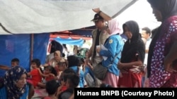 Petugas Badan Nasional Penanggulangan Bencana dan relawan pendamping, menghibur para pengungsi anak-anak pengungsi di tenda pengungsi kabupaten Pidie Jaya. (Foto: Humas BNPB)