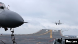 FILE - China's Liaoning aircraft carrier is shown in an area of South China Sea, Jan. 2, 2017. A U.S. plane and a Chinese military aircraft came close to each other Thursday over the South China Sea.