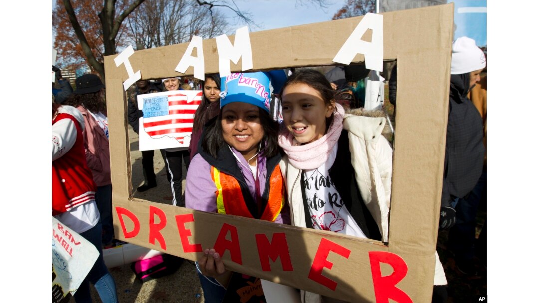 Demonstran Karina Velasco, kiri, dan Gabi Sanchez memegang poster dalam demo mendukung program perlindungan untuk anak imigran atau the Deferred Action for Childhood Arrivals (DACA), dan Status Terlindungi Sementara diCapitol Hill, di Washington, 6 Desember 2017.