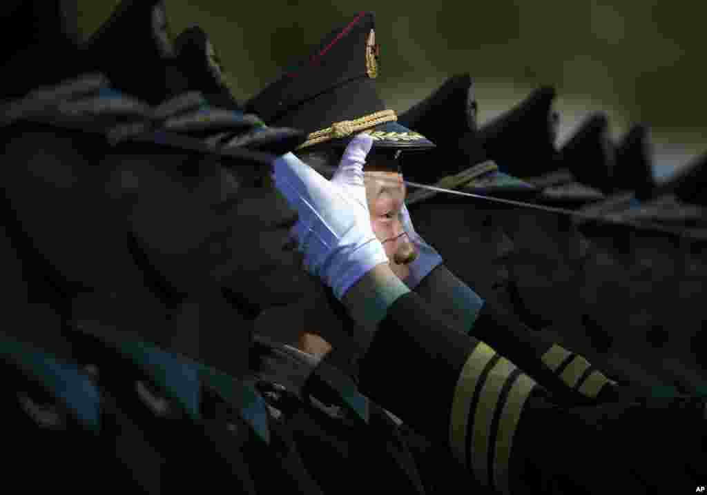 A Chinese People&#39;s Liberation Army soldier adjusts a hat of a member of a guard of honor as they prepare for a welcome ceremony for visiting Italian Prime Minister Matteo Renzi held outside the Great Hall of the People in Beijing.