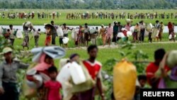 FILE - Rohingya refugees, who crossed the border from Myanmar two days before, walk after they received permission from the Bangladeshi army to continue on to the refugee camps, in Palang Khali, near Cox's Bazar, Bangladesh, Oct. 19, 2017.