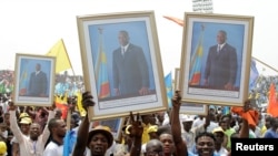 Les militants du président congolais Joseph Kabila, porte son portrait lors d'un meeting pro-gouvernement à Kinshasa, RDC, le 29 juillet 2016.