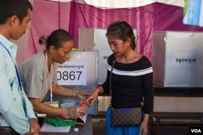 រូបឯកសារ៖ មន្ត្រីគ.ជ.ប ជ្រលក់ដៃអ្នកដែលបោះឆ្នោតរួចក្នុងទឹកខ្មៅពិសេសដែលលុបមិនជ្រះដើម្បីសំគាល់ថាបានបោះឆ្នោតរួចហើយ នៅក្នុងការិយាល័យបោះឆ្នោតមួយក្នុង សង្កាត់ស្ទឹងមានជ័យខ័ណ្ឌមានជ័យក្រុងភ្នំពេញ កាលពីថ្ងៃទី៤ ខែមិថុនា ឆ្នាំ២០១៧។ (នៅ វណ្ណារិន/VOA)