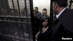 People accused of working for unlicensed non-governmental organizations awaiting trial hearings in a cage, Cairo, March 8, 2012.