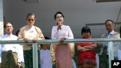 အဖွဲ့ချုပ်ရုံးရှေ့က လူထုကို နှုတ်ဆက်နေတဲ့ ဒေါ်အောင်ဆန်းစုကြည်နဲ့ ဦးတင်ဦး။ (နိုဝင်ဘာ ၉၊ ၂၀၁၅)