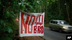 In this June 13, 2017, photo, a sign that reads "no to industrial forestry plantations and BRS," a reference to Bangun Rimba Sejahtera, the company that's a front for Asia Pulp & Paper's expansion in Indonesia.