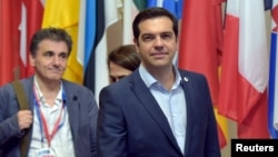 Greece's Prime Minister Alexis Tsipras (C) and Greek Finance Minister Euclid Tsakalotos (L) leave a eurozone leaders summit in Brussels, Belgium, July 13, 2015.